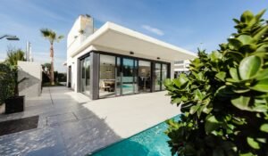 white and grey concrete building near swimming pool under clear sky during daytime